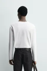 Camiseta de manga larga con cuello redondo y cierre frontal de botonadura tipo henley. Confeccionada en tejido de algodón y seda, con un corte relajado.