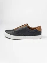 Champion de estilo urbano en color azul marino, con detalles en cuero sintético color suela en la lengüeta y el talón. Presenta perforaciones decorativas en los laterales y suela de goma blanca.
