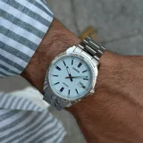 Reloj analógico Casio con caja y malla de acero inoxidable plateado. Presenta una esfera de color celeste claro con acabado texturizado, índices y manecillas plateadas, y ventana de fecha a las 3.