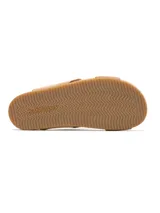Sandalias tipo slide color tostado con tiras cruzadas de cuero y base plana de plataforma.