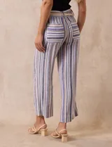 Pantalón de lino a rayas verticales en tonos azul, beige y blanco, con corte wide leg, pretina con pasadores, cierre y botón. Incluye cinturón de soga con hebilla redonda.