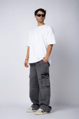 Pantalón jean cargo de corte oversize y tiro medio, con bolsillos laterales tipo cargo y costuras reforzadas en las rodillas.