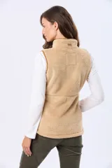 Chaleco de tejido sherpa color beige, con cuello alto y detalles en eco cuero. Diseño sin mangas que proporciona abrigo al torso manteniendo la libertad de movimiento.