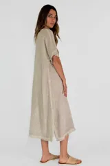 Vestido midi color amarillo, de corte suelto y manga corta, con ruedo desflecado.