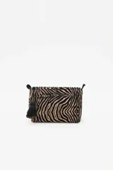Bolso tipo neceser de terciopelo con estampado animal print de cebra, cierre superior y detalle de borla decorativa con cuentas en el lateral.