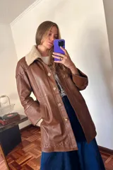 Tapado largo de cuero ovino color caramelo con cuello de piel sintética desmontable, detalles de pasamanería a tono en hombros y espalda y botones de guampa.