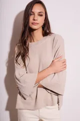 Sweater color beige de tejido de punto, con cuello redondo y mangas 3/4 con volados.