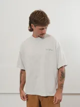 Remera gris jaspeado de algodón con corte boxy fit y bordado de olas verdes en el pecho.