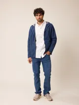 Campera de nylon con cierre frontal, capucha ajustable con cordones y forro interior a cuadros. Presenta bolsillos laterales y logo bordado en el pecho.