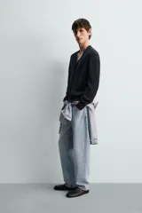 Pantalón de jean color celeste con efecto lavado, de corte recto y tiro medio, con diseño de cinco bolsillos y cierre frontal con botones.
