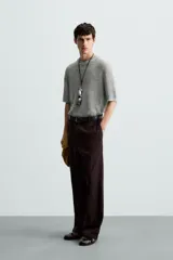 Camiseta de punto calado, color gris claro, de corte relajado (relaxed fit), con cuello redondo y mangas cortas.