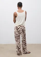 Pantalón fluido de tiro medio con estampado de cebra, diseño recto y largo, cintura elástica con cordón de ajuste y forro interior de algodón.