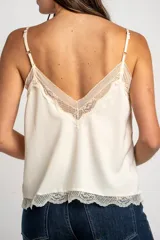 Blusa satinada marrón con detalles de encaje en el escote en V y en el ruedo. Presenta tirantes finos regulables.