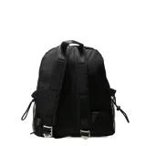 Mochila urbana negra con diseño de costuras geométricas en relieve. Presenta un bolsillo frontal con cierre, bolsillos laterales de red y un parche decorativo con la inscripción 'Oreiro Love'. Incluye tiradores de cierre con cordones trenzados en tonos rojo, blanco y negro.