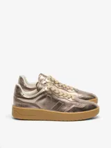 Championes Veja modelo V-90, con diseño de cuero metalizado en tono cobre. Presentan el logo de la marca en el lateral, cordones al tono y una suela de goma color caramelo.