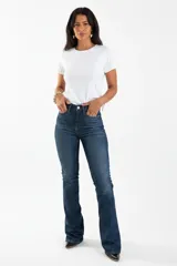 Pantalón jean de corte slim con pierna oxford y cintura alta, en tono azul oscuro con sutiles zonas desgastadas.
