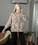 Sweater de tejido de punto con diseño abstracto de líneas blancas sobre fondo de color sólido. Presenta un corte clásico y textura suave.