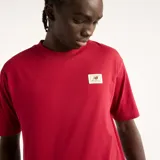 Remera New Balance de corte regular fit y color rojo, con cuello redondo y una pequeña etiqueta tejida de la marca en el pecho.