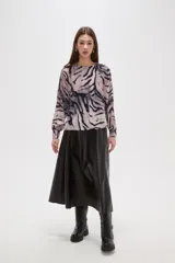 Blusa de manga larga con estampado animal print abstracto en tonos grisáceos y negros. Presenta cuello a la base y cierre con botón en la parte posterior.