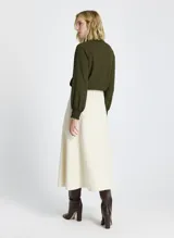 Falda midi color crudo, de tela tejida, con bolsillos delanteros, cierre frontal con cremallera y botón, y trabillas para cinturón.