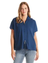 Cardigan de punto azul, con cierre frontal metálico completo, cuello con solapa y mangas cortas de sisa caída. Presenta un corte recto y holgado.