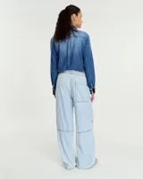 Pantalón celeste de denim camisero liviano, corte pijama relajado, con cintura elastizada y tira de ajuste. Tiene bolsillos laterales, recortes en rodilla, cintura al corte con efecto deshilachado, jareta con tiras para regular en el ruedo y bolsillo plaqué en la espalda.
