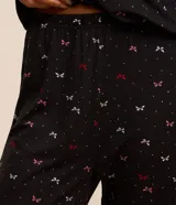 Conjunto de pijama largo negro con estampado de mariposas en tonos rosa y blanco. Incluye una blusa de manga larga y un pantalón con lazo ajustable en la cintura.