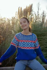 Sweater azul con diseño geométrico en blanco y rojo en la parte superior. Tejido en lana suave y liviana.