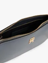 Cartera tipo baguette de Tommy Hilfiger con acabado liso, cierre de cremallera y correa de cadena metálica dorada. Presenta el monograma TH en la parte frontal.