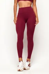 Calza deportiva de talle alto color bordó, confeccionada en poliamida sin costura frontal para mayor comodidad y ajuste perfecto.