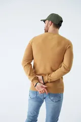 Sweater de punto con textura geométrica, color gris, de cuello redondo y manga larga. Presenta puños y ruedo acanalados con detalle de borde en color oscuro y logo bordado en el pecho.