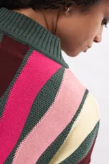 Buzo de tejido de punto con diseño de rayas verticales multicolores en tonos verde oscuro, fucsia, rosa claro y crema. Presenta cuello redondo, puños y ruedo acanalados.