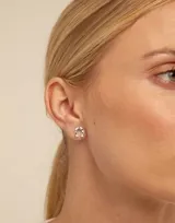 Aro piercing de metal plateado con forma de herradura y pequeños detalles circulares.