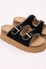 Sandalias negras con plataforma liviana, doble tira en símil gamuza, costuras decorativas en blanco y hebillas metálicas doradas.