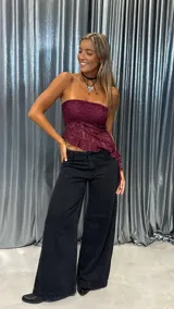 Top strapless de encaje color bordó, con diseño asimétrico y terminación con volados en el ruedo.