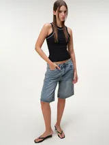 Musculosa de tela rib color marfil, con escote nadador, corte ajustado al cuerpo y costuras a contratono en color marrón.