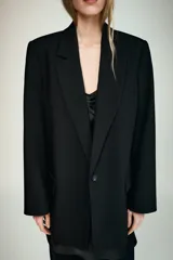 Blazer de cuello solapa y manga larga, con bolsillos delanteros con solapa y cierre frontal de un botón. Presenta un diseño estructurado con forro interior.