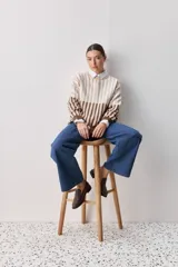 Sweater de tejido jacquard con diseño de rayas verticales en tonos rojo, blanco y azul. Presenta cuello redondo, hombros caídos y puños en contraste de color azul.
