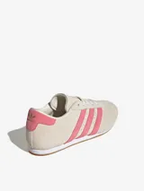 Championes Adidas Taekwondo Lace color crema con las tres tiras laterales en rosa.
