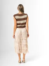 Maxi falda color beige con flecos escalonados y diseño de capas, confeccionada en tela elastizada con cintura elástica.