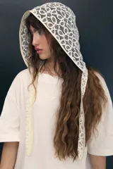 Capucha de encaje negro con diseño de escamas, ajustable y confeccionada en poliamida.