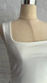 Top corto blanco de breteles finos y escote cuadrado.