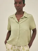 Camisa verde claro de manga corta con cuello camisero y botones.