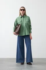 Camisa blanca de algodón con diseño utilitario y calce relajado. Presenta dos bolsillos frontales de estilo cargo con tapa y costuras a contratono.