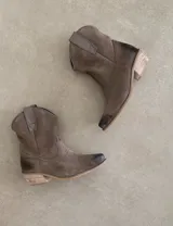 Bota corta estilo western de cuero color marrón, con taco cuadrado de 5 cm y diseño clásico. Presenta un acabado desgastado en la puntera y el talón.