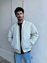 Campera bomber color crudo de nylon con cierre frontal y bolsillos laterales.