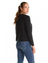 Cardigan tejido de punto color beige, con cuello a la base y cierre frontal mediante un botón metálico decorativo. Presenta mangas largas y corte recto.