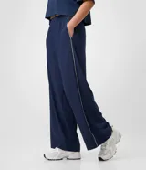 Pantalón deportivo Get Over de corte recto y suelto, confeccionado en microfibra azul marino con cintura elastizada y vivo lateral en color blanco.