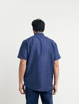 Camisa azul con estampado de lunares blancos, de manga corta y corte clásico.