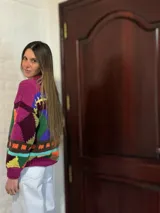 Sweater de lana merino con estampado Fair Isle en tonos azul marino, beige, naranja, verde oliva y bordó. Tiene cuello redondo y mangas largas.
